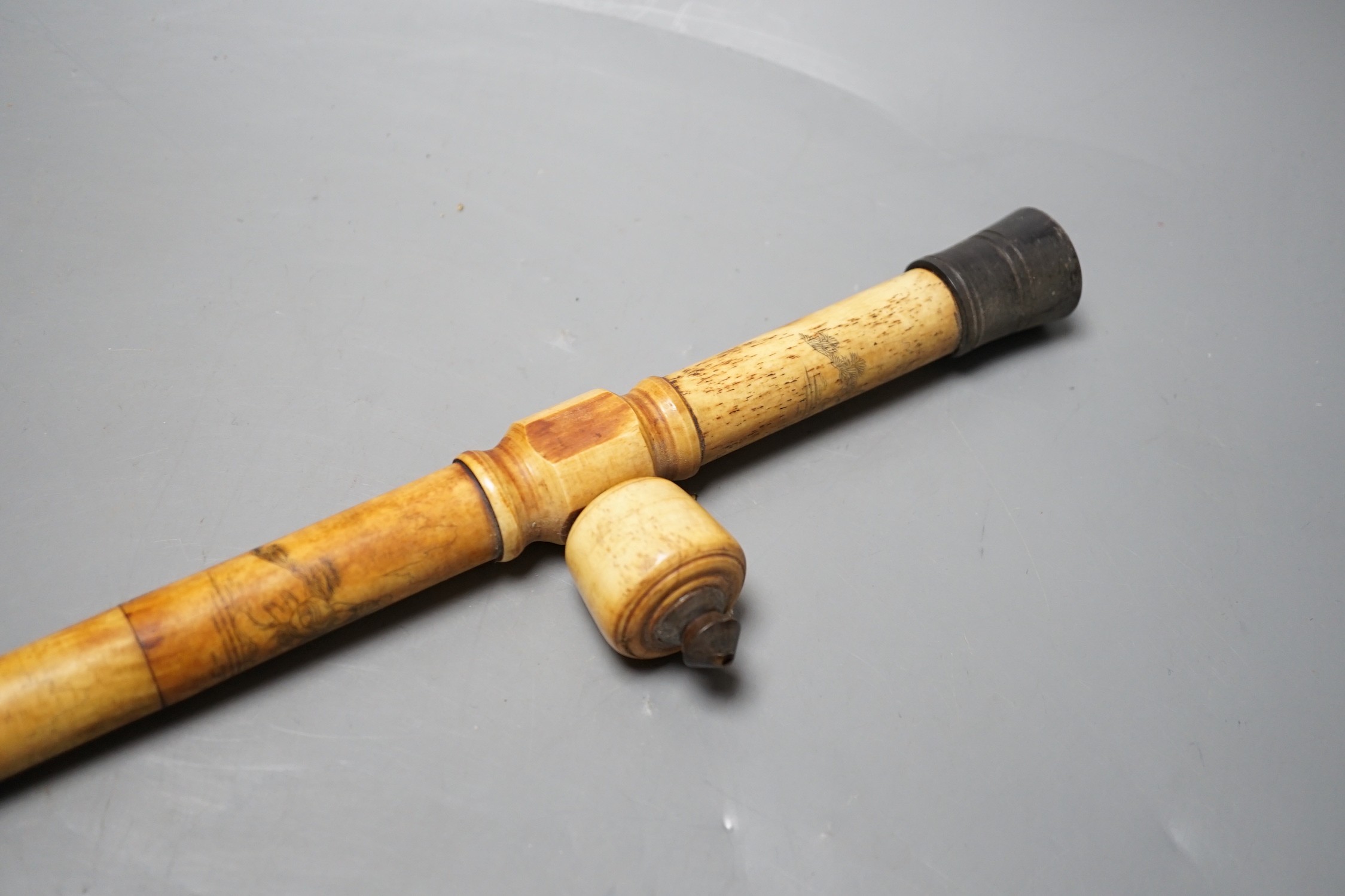 A Chinese bone opium pipe with figural decoration, 46cm wide